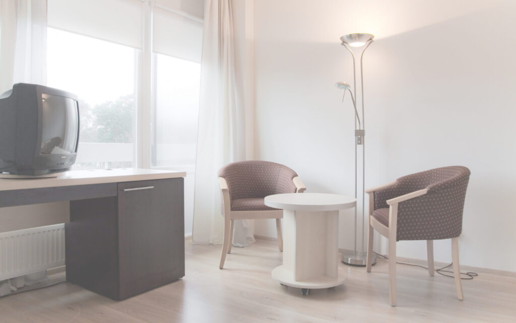 白いテーブルと椅子が並ぶ明るい室内